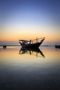 Silhouette boat in sea against sky during sunset