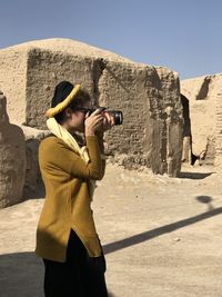 Side view of woman photographing on mountain