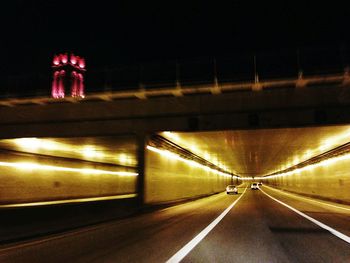 Illuminated tunnel at night