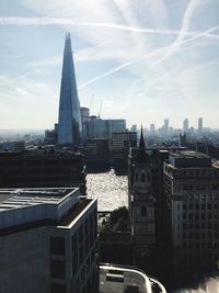 Buildings in city against cloudy sky