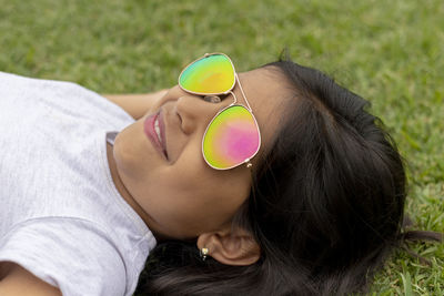 Close-up of smiling girl wearing sunglasses on grassy field 