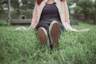 Midsection of woman sitting on field