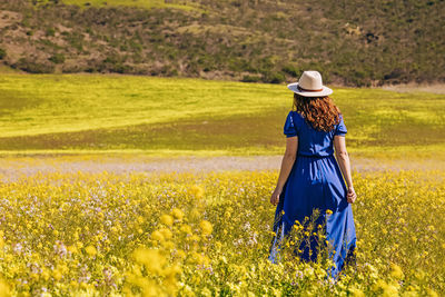 Rear view of woman standing on field