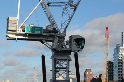 Low angle view of crane against sky