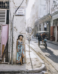 A blond woman wearing a colorful dress in the streets of havana. 
