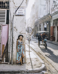 Woman on street amidst buildings in city