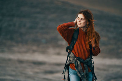 Young woman looking away while standing on beach