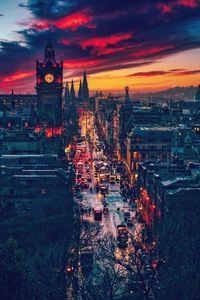 Illuminated buildings in city during sunset