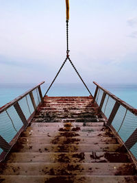 Low angle view of pier on sea against sky