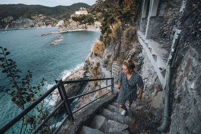 Young female climbing stairs on coastal path in cinque terre