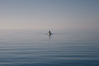 Man standing in sea against clear sky