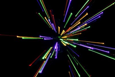 Low angle view of illuminated lights against black background