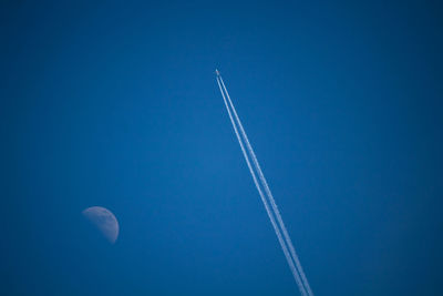 Low angle view of vapor trail against blue sky