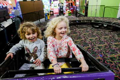 Two girls smiling and laughing on rollercoaster having fun