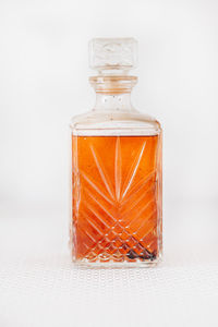 Close-up of glass jar on table against white background