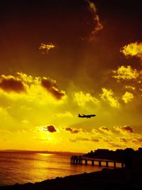 Scenic view of sea against dramatic sky during sunset