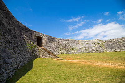 View of stone wall of an old okinawa castle against blue sky