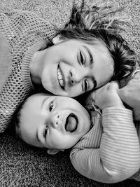Black and white portrait of smiling sister and brother lying down