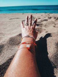 Low section of person on sand at beach