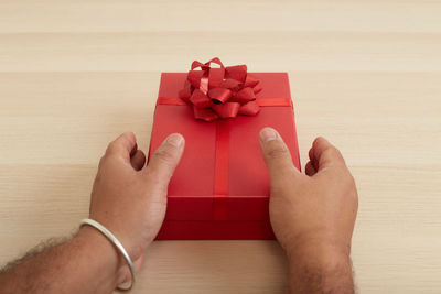 Midsection of person holding red table