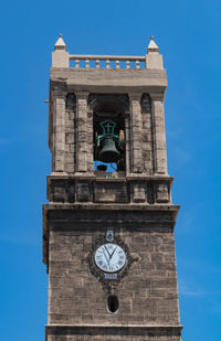 Low angle view of clock tower against blue sky