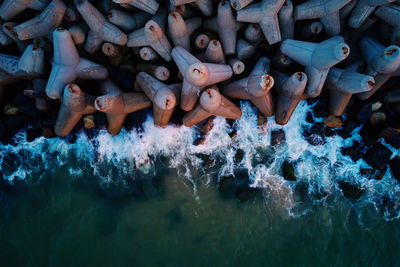 Waves break on concrete tetrapod breakwaters at sea coast. protection from large waves