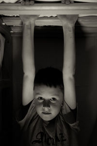 Portrait of playful boy holding roof beam