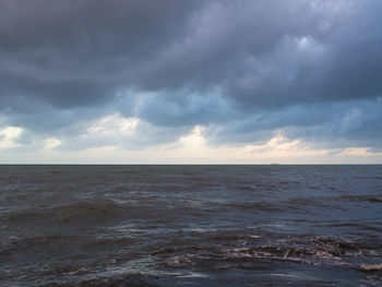 Scenic view of sea against storm clouds