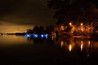 Scenic view of lake against sky at night