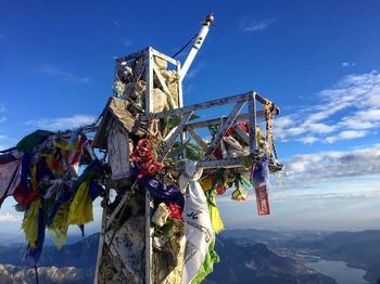 Prayer flags on structure at cliff against blue sky