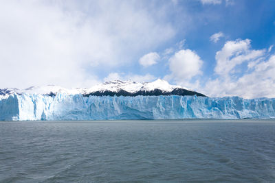 Scenic view of sea and snowcapped mountain against sky