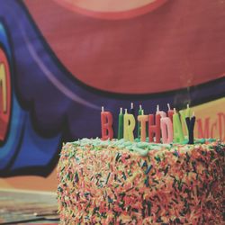 Close-up of text candles on birthday cake on table