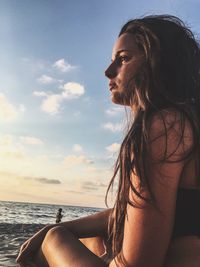 Woman at beach against sky