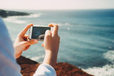 Close-up of woman photographing sea