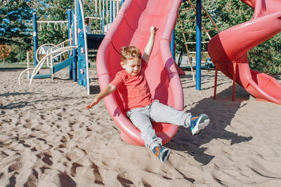 Boy playing on slide in playground