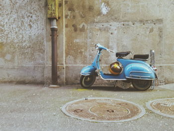 Vintage car on street against wall in city