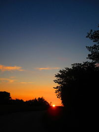 Silhouette trees against sky during sunset