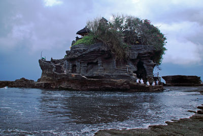 Rock formations by sea against sky