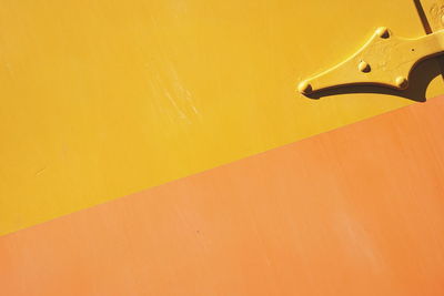 Full frame shot of yellow table against orange wall