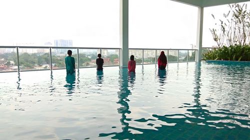 People in swimming pool against sky