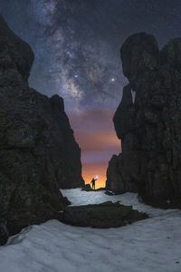 Scenic view of rock formations in sea against sky at night