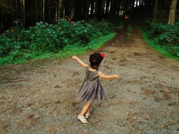 Rear view of woman standing on road