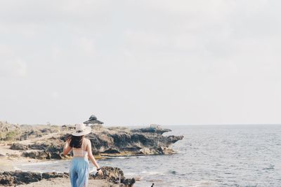 Rear view of woman looking at sea against sky