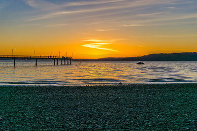 A view of the pier in des moines, washington. the sun is setting.