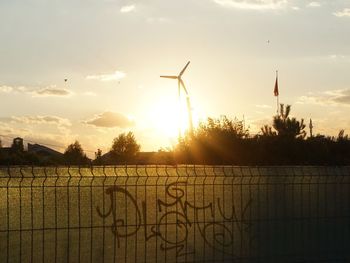 View of wind turbine against sky during sunset