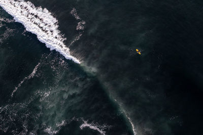 High angle view of airplane flying over sea against sky