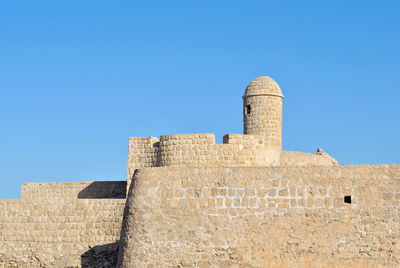 Low angle view of castle against clear blue sky