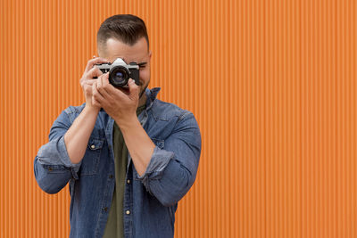 Portrait of a young man taking a photograph