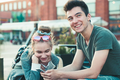 Portrait of a smiling young woman sitting outdoors