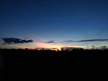 Silhouette trees on field against sky at sunset